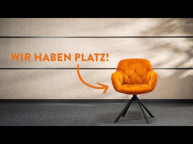 meinkarrierestart.at Auf einem dunklen Boden vor einer beigen Wand steht ein orangefarbener Polsterstuhl mit dem deutschen Text „WIR HABEN PLATZ!“ und einem Pfeil, der auf den Stuhl zeigt.
