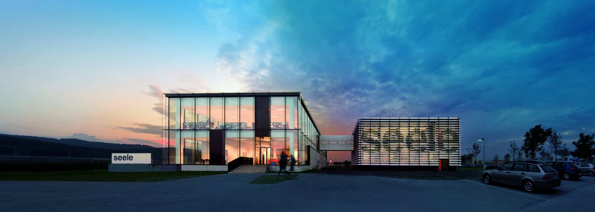 meinkarrierestart.at Modernes Bürogebäude aus Glas in der Abenddämmerung mit beleuchtetem Innenraum, angrenzend an eine Struktur aus horizontalen Lamellen, davor parkende Autos und auf dem Rasen ist ein „Seele“-Schild zu sehen.